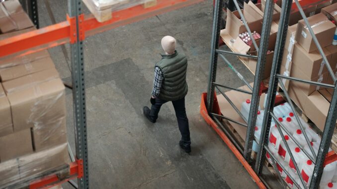 Pracownik w magazynie między regałami – planowanie układu magazynu i najczęstsze błędy generujące straty