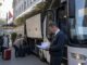 Kierowca autokaru sprawdza dokumenty przewozowe przed wyjazdem grupy spod hotelu.