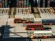 Transport kontenerów morskich za pomocą pojazdów terminalowych w porcie przeładunkowym.