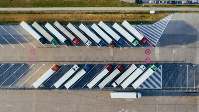 Widok z lotu ptaka na parking dla samochodów ciężarowych i tirów w centrum logistycznym.