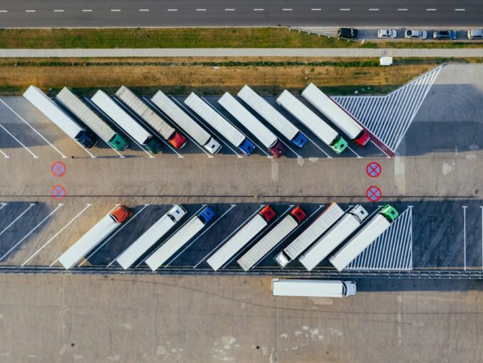 Widok z lotu ptaka na parking dla samochodów ciężarowych i tirów w centrum logistycznym.